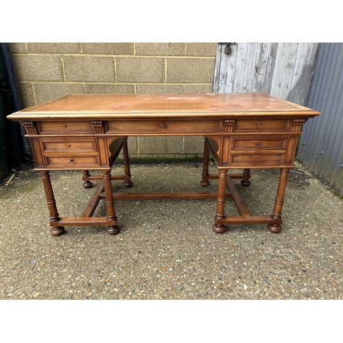 37 - A  large continental mahogany writing desk, five drawers and two sliding extensions with a golden le... 