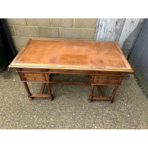 37 - A  large continental mahogany writing desk, five drawers and two sliding extensions with a golden le... 