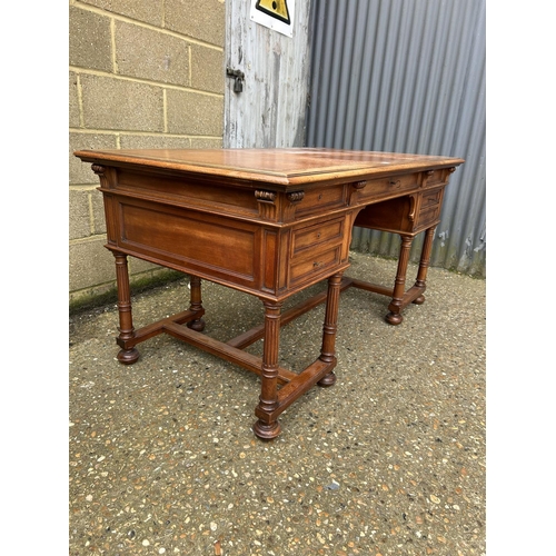 37 - A  large continental mahogany writing desk, five drawers and two sliding extensions with a golden le... 