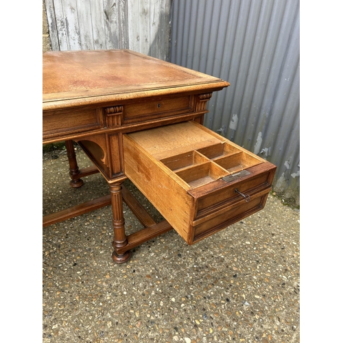 37 - A  large continental mahogany writing desk, five drawers and two sliding extensions with a golden le... 