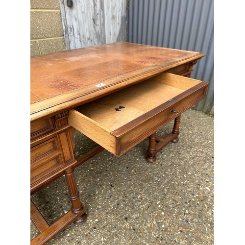 37 - A  large continental mahogany writing desk, five drawers and two sliding extensions with a golden le... 