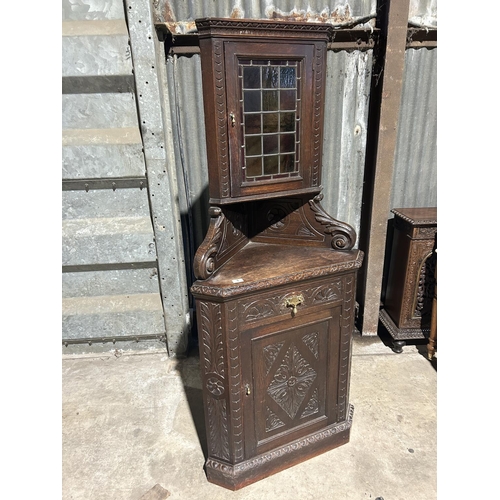 5 - An unusual carved oak corner cupboard with leaded glass top