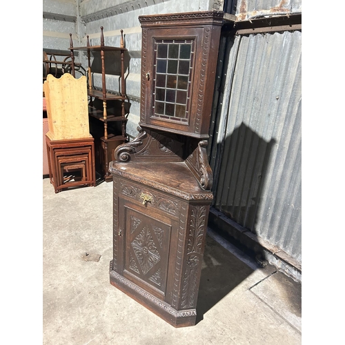 5 - An unusual carved oak corner cupboard with leaded glass top