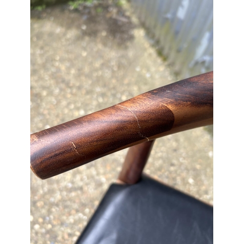 51 - A rosewood cow horn chair with black vinyl seat