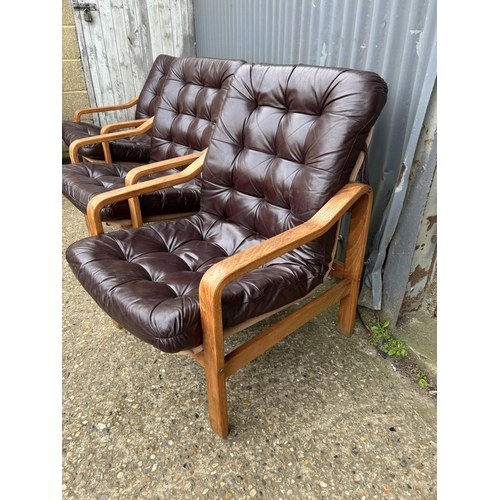 52 - Three teak framed lounger chairs with brown leather seats