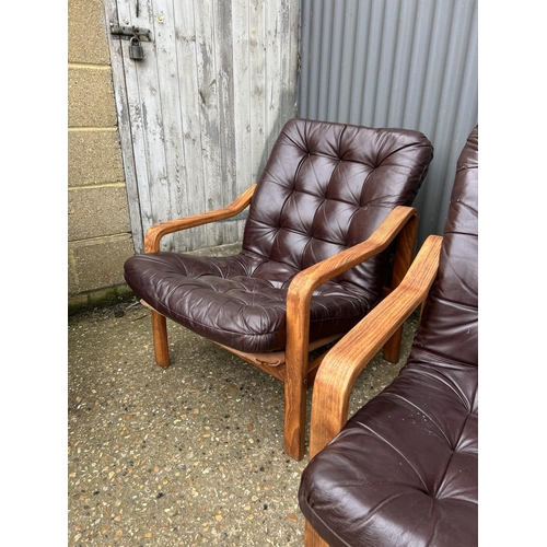 52 - Three teak framed lounger chairs with brown leather seats