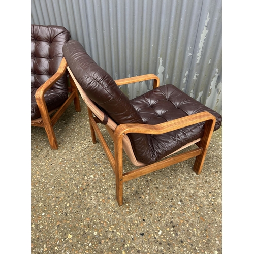 52 - Three teak framed lounger chairs with brown leather seats