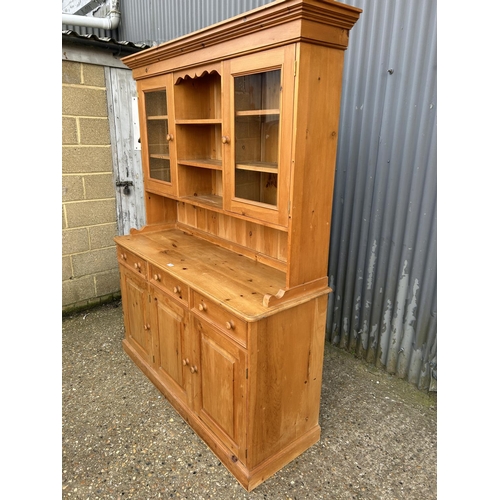 73 - A large solid pine dresser with cabinet top over three drawer base 152x50x20