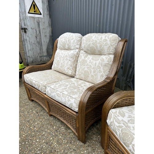 116 - A wicker three piece conservatory suite consisting of a two seater sofa and two chairs