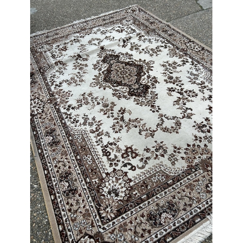 127 - A brown pattern rug 340x 240 together with a circular rug