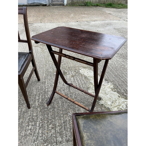 134 - A mahogany folding table together with two mahogany chairs with green leather seats