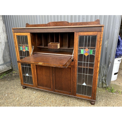 168 - A early 20th oak bureau cabinet with fall front and leaded glass doors 152x36x130