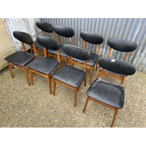 79 - A set of 8 teak mid century dining chairs with black vinyl upholstery