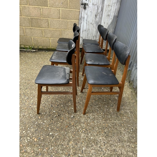 79 - A set of 8 teak mid century dining chairs with black vinyl upholstery