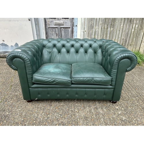 87 - A green leather two seater chesterfield sofa 155cm wide