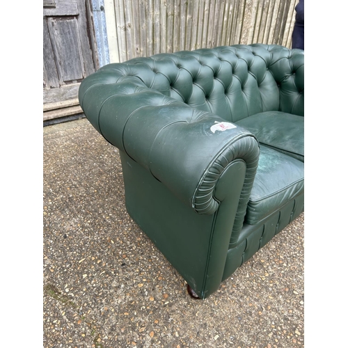 87 - A green leather two seater chesterfield sofa 155cm wide