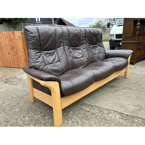 88 - A STRESSLESS brown leather three seater reclining sofa by EKORNES