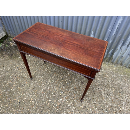 101B - An Edwardian mahogany inlaid fold over card table with cards