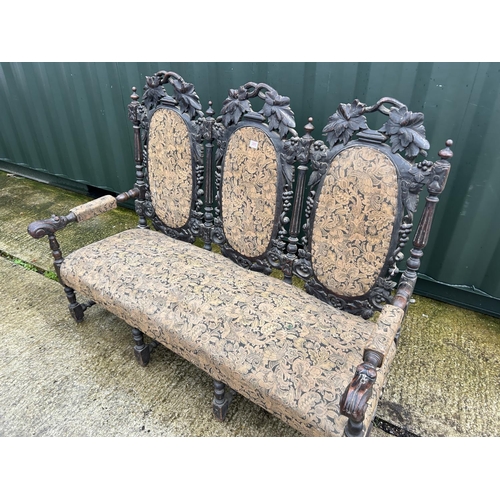 280J - An antique Jacobean style carved oak three seater settle with upholstered seat and back panels, 165 ... 