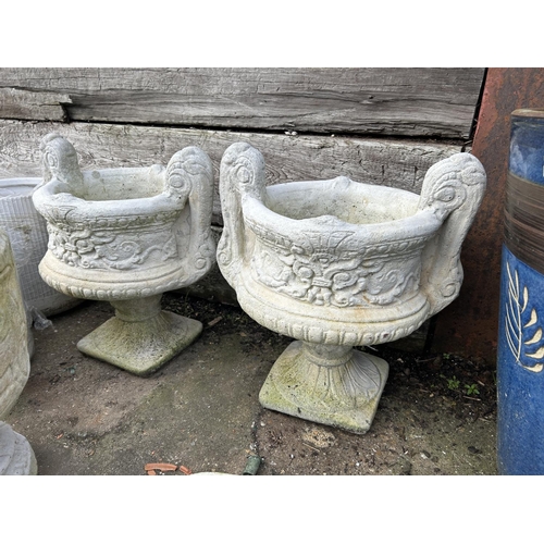 310G - A pair of fleur de lys pedestal urns