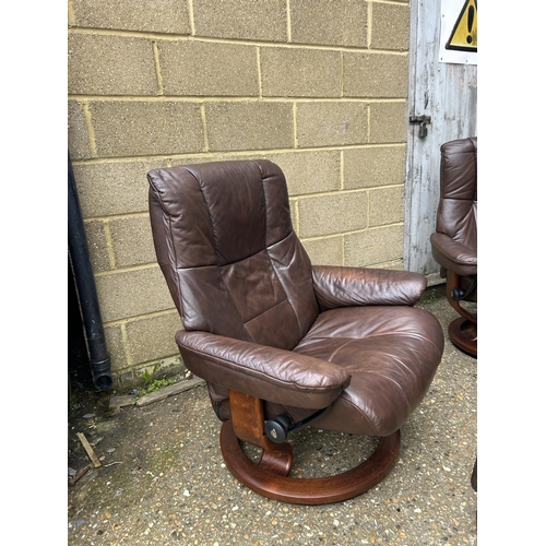 100 - A pair of EKORNES brown leather stressless recliner chairs with matching stools