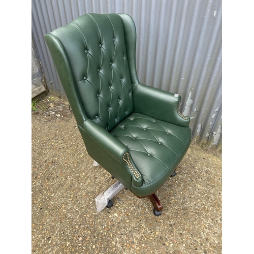 125 - A green leather chesterfield style swivel chair as new