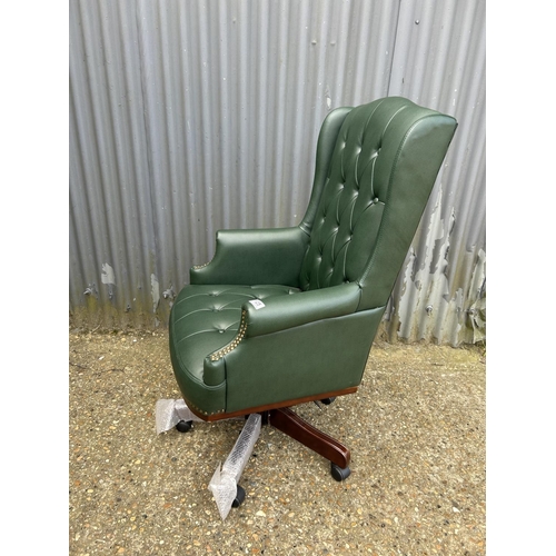 125 - A green leather chesterfield style swivel chair as new