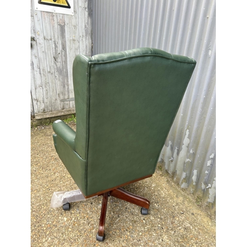 125 - A green leather chesterfield style swivel chair as new