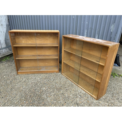 139 - Two mid century glazed bookcases with sliding doors  90x23x90