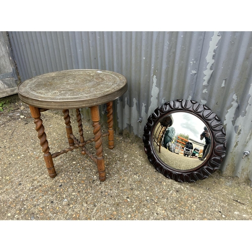 155 - A brass tray top table on folding oak barley twist support together with a carved oak convex mirror