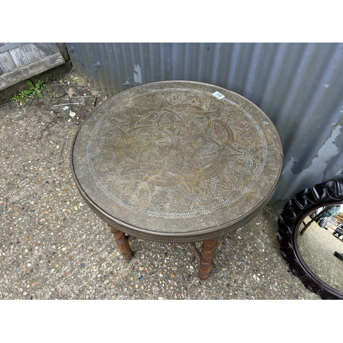 155 - A brass tray top table on folding oak barley twist support together with a carved oak convex mirror