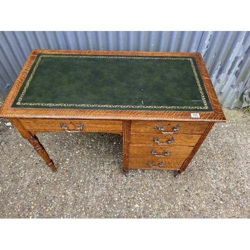 166 - An oak kneehole writing desk with a green leather top 108x56x75