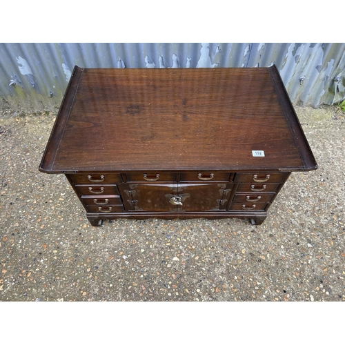 193 - A double sided oriental hardwood coffee table with drawers and doors to each side 90x58x50