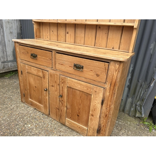 232 - A country pine dresser with plate rack top over two drawer and two door base 138x44x220