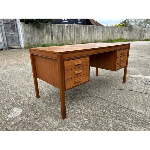 24 - A mid century teak kneehole desk labelled MADE IN NORWAY 150x77x74