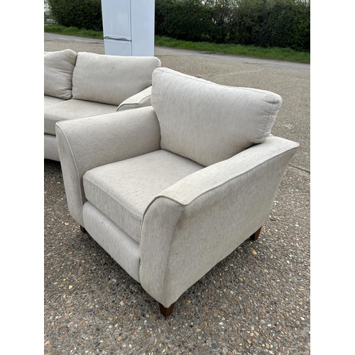 253 - A beige upholstered four piece lounge suite consisting of two seater sofa, two chairs and a footstoo... 