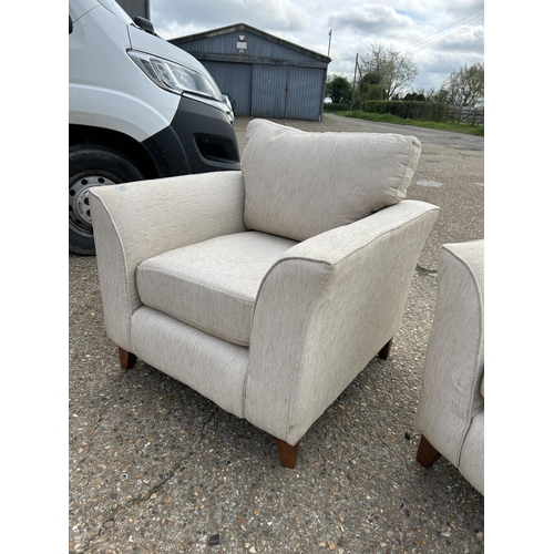 253 - A beige upholstered four piece lounge suite consisting of two seater sofa, two chairs and a footstoo... 