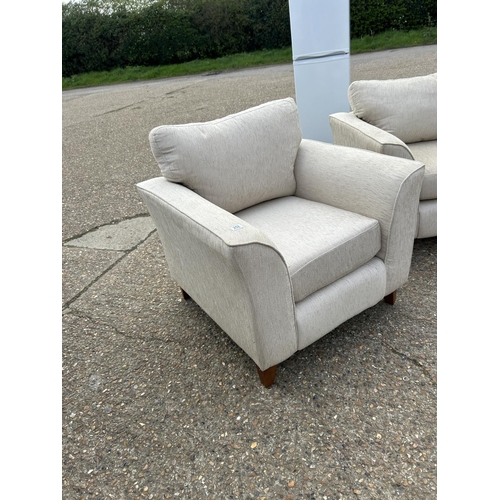 253 - A beige upholstered four piece lounge suite consisting of two seater sofa, two chairs and a footstoo... 