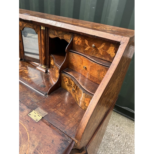 331 - An early Dutch marquetry inlaid bureau with fitted interior writing well and three long drawers rais... 