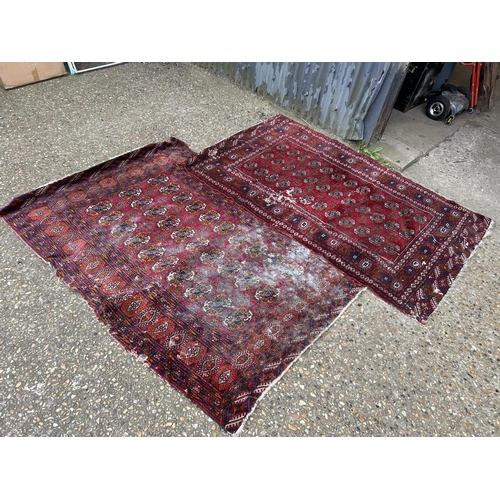 54 - A near pair of worn red oriental pattern rugs 120x200