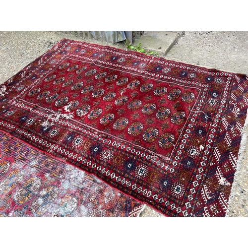 54 - A near pair of worn red oriental pattern rugs 120x200