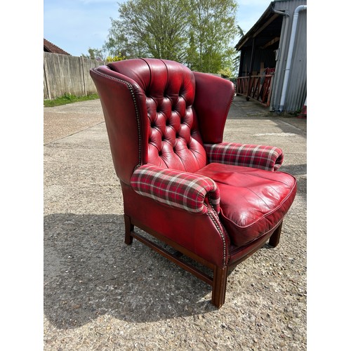 260 - A red leather chesterfield wing back chair with tartan pattern arm rests