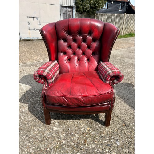 260 - A red leather chesterfield wing back chair with tartan pattern arm rests