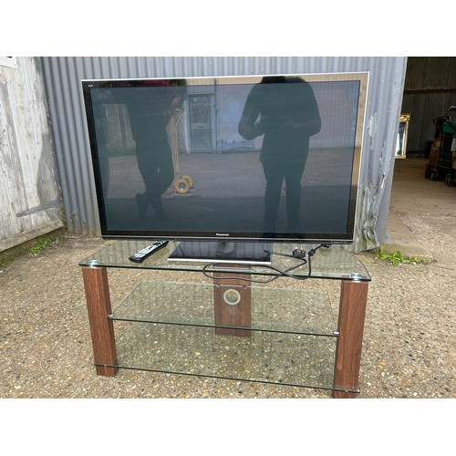 278 - A 42inch Panasonic tv with lead, remote and manual on modern clear glass stand