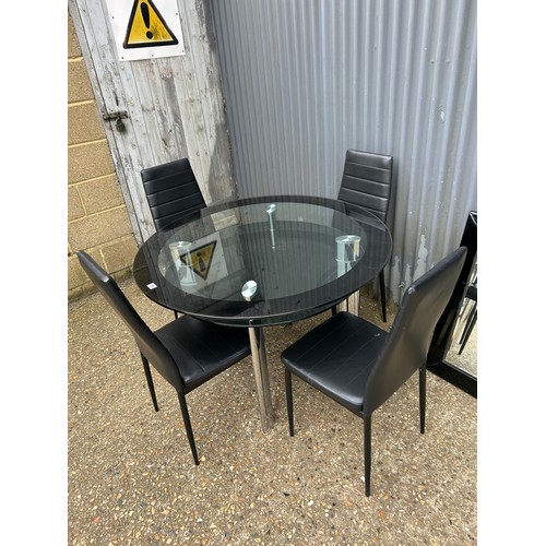 188 - A modern black glass top table 110cm together with four chairs and matching wall mirror