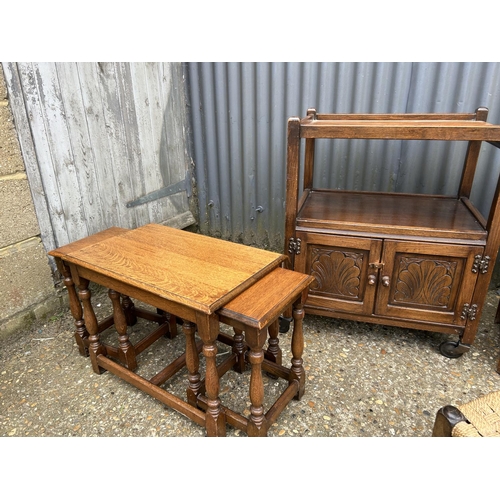 119 - An oak trolley, oak nest of three, three stools and a book table