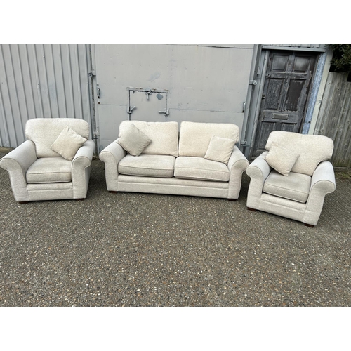 130 - A modern beige upholstered three piece lounge suite consisting of two seater sofa and two chairs