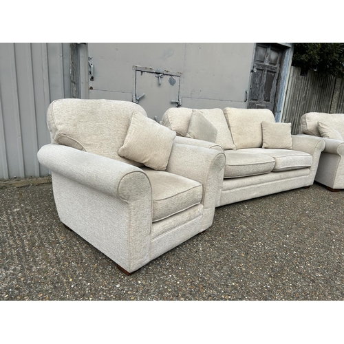 130 - A modern beige upholstered three piece lounge suite consisting of two seater sofa and two chairs