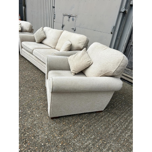 130 - A modern beige upholstered three piece lounge suite consisting of two seater sofa and two chairs