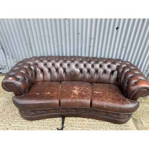 157 - A brown leather kidney shaped chesterfield sofa